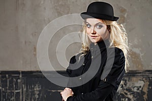 Portrait of a beautiful steampunk woman hat-bowler hat over grunge background.