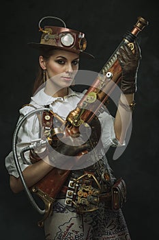 Portrait of a beautiful steampunk woman holding a gun