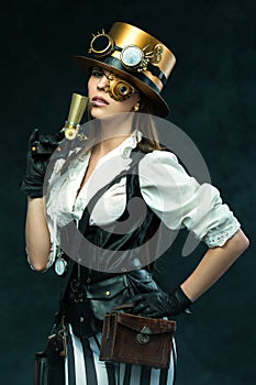 Portrait of a beautiful steampunk woman holding a gun