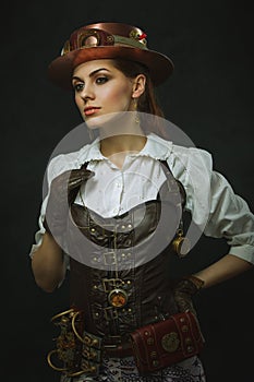 Portrait of a beautiful steampunk woman over dark background.