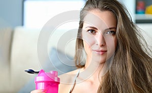Portrait of beautiful strong happy young athletic woman with bottle of drinking water