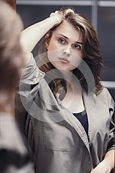 Portrait of a beautiful strong woman with make-up, reflection of a confident girl getting ready for work, concept of female