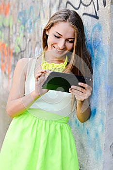 Portrait of beautiful stylish blonde young woman using tablet pc computer having fun happy smiling