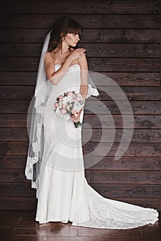 Portrait of a beautiful stylish young bride. Makeup and hairstyle on woman. Stylish white wedding dress and bouquet