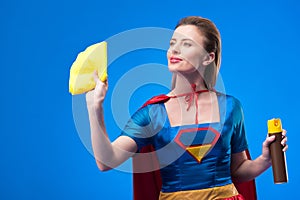 portrait of beautiful superwoman with rag and detergent for cleaning