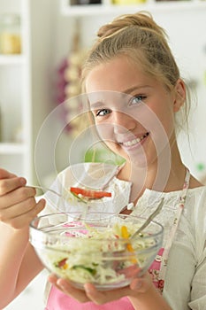 Portrait of beautiful teenager girl coocking on kitchen