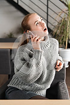 Portrait of a beautiful teenager relaxing and using a mobile phone to have a conversation with friends, smiling and