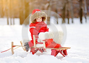 Portrait of beautiful toddler boy having fun in winter park