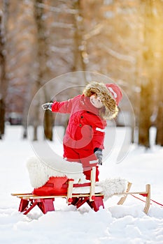 Portrait of beautiful toddler boy having fun in winter park