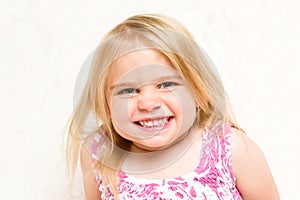 Portrait of Beautiful Toddler Girl Grinning Cheekily photo