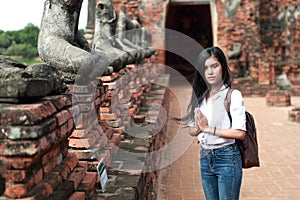 Portrait of beautiful traveler asian woman paying respect in ancient temple