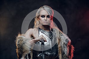 Portrait of a beautiful warrior woman holding a sword wearing steel cuirass and fur. Fantasy fashion. Cosplayer as Ciri