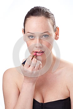 Portrait of beautiful woman applying lipstick