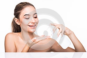 Portrait of beautiful woman applying some cream to her face for skin care. Cosmetology concept.