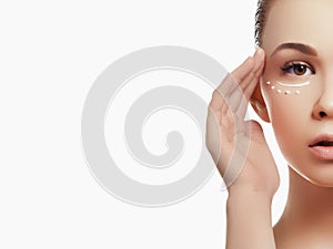 Portrait of beautiful woman applying some cream to her face for skin care