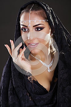 Portrait of a beautiful woman with arabian makeup in black paranja photo