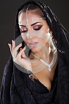 Portrait of a beautiful woman with arabian makeup in black paranja photo