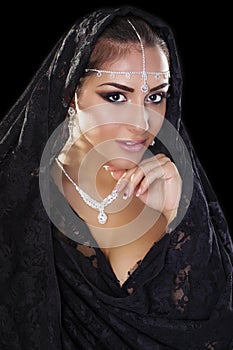 Portrait of a beautiful woman with arabian makeup in black paranja