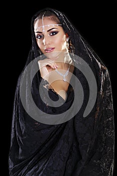Portrait of a beautiful woman with arabian makeup in black paranja