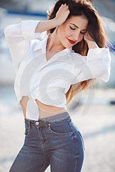 Portrait of a beautiful woman on the background of the sea and yachts