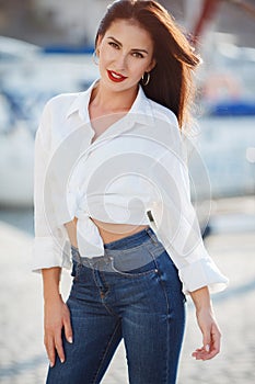 Portrait of a beautiful woman on the background of the sea and yachts