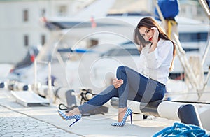 Portrait of a beautiful woman on the background of the sea and yachts