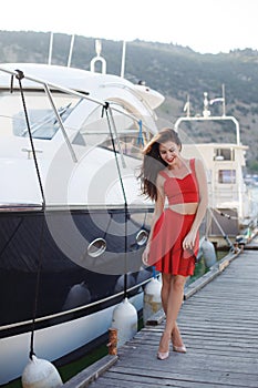 Portrait of a beautiful woman on the background of the sea and yachts