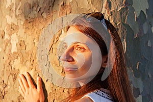 Portrait of beautiful woman on background of sycamore tree