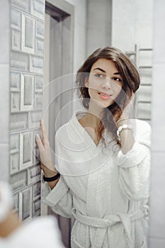 Portrait of a beautiful woman in bathroom. cheerful young girl washes, brushes her teeth with a toothbrush