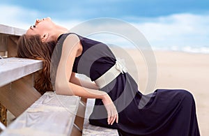 Portrait of a beautiful woman on the beach. She Looks at the sky.