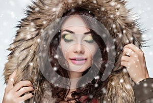 Portrait of a beautiful woman with beautiful make-up and manicure in a fur coat
