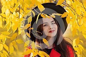 portrait of beautiful woman in a black hat and with red lipstick walks