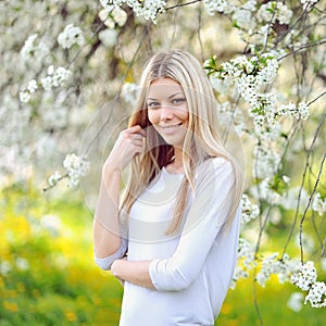 Portrait of beautiful woman in blooming tree in spring