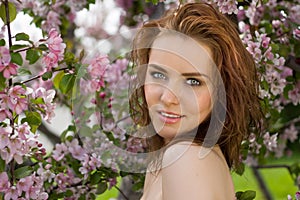 Portrait of beautiful woman in blossom orchard