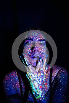 Portrait of a beautiful woman with blue sequins on her face. Girl with artistic make-up in Light color. Fashion model