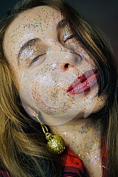 Portrait of a beautiful woman with blue sparkles on her face. Girl with colorful artistic make-up with glitter. Fashion