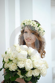 Portrait of a beautiful woman with a bouquet of white roses