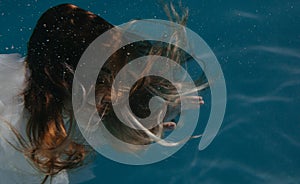 Portrait of beautiful woman in bridal dress underwater