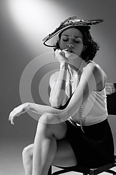 Portrait of beautiful woman in character of famous fashion designer posing in stylish classic suit. Black and white