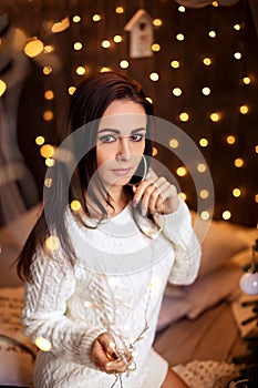 Portrait of a beautiful woman in the Christmas decorations, festive mood
