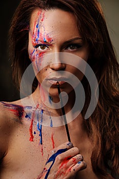 Portrait of beautiful woman with creative colored makeup on a dark background.