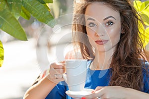Portrait of beautiful woman drinking coffe in a coffee shop
