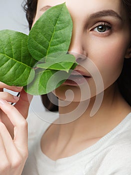 Portrait beautiful woman face portrait with green leaf , concept for skin care or organic cosmetics