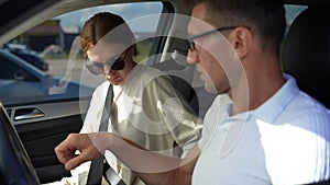 Portrait of beautiful woman fastening seat belt listening blurred man talking. Concentrated focused Caucasian girlfriend