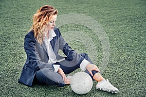 Portrait of a beautiful woman football player in a strict office suit, concept sports office manager leisure