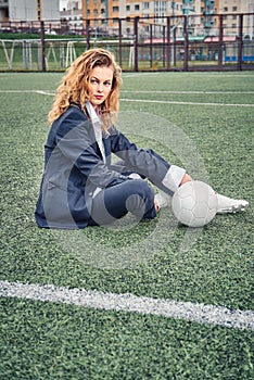 Portrait of a beautiful woman football player in a strict office suit, concept sports office manager leisure