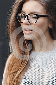 Portrait of beautiful woman in glasses on gray background photo