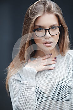 Portrait of beautiful woman in glasses on gray background photo