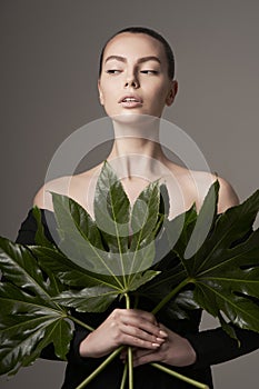 Portrait of a beautiful woman with grass leaves in her hands