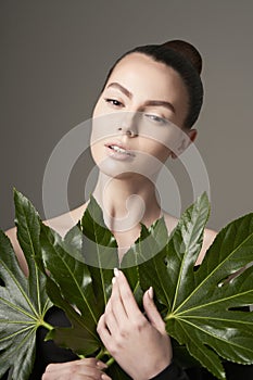 Portrait of a beautiful woman with grass leaves in her hands